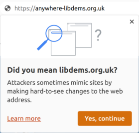 A browser address bar showing "anywhere-libdems.org.uk" with a pop-up error message reading "Did you mean libdems.org.uk? Attackers sometimes mimic sites by making hard-to-see changes to the web address."